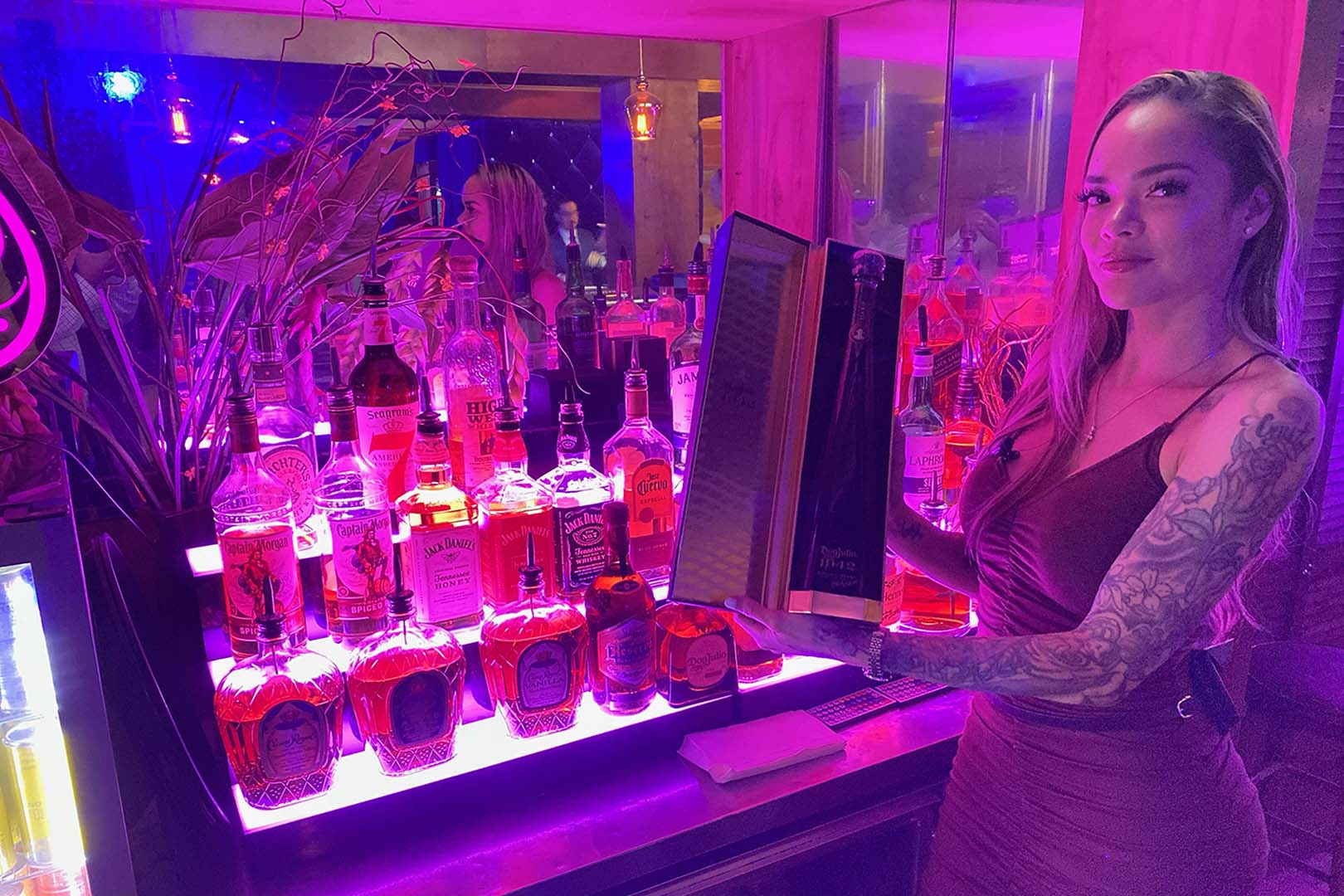 A bartender behind the lit backbar at Rachel's North in Casselberry, Florida