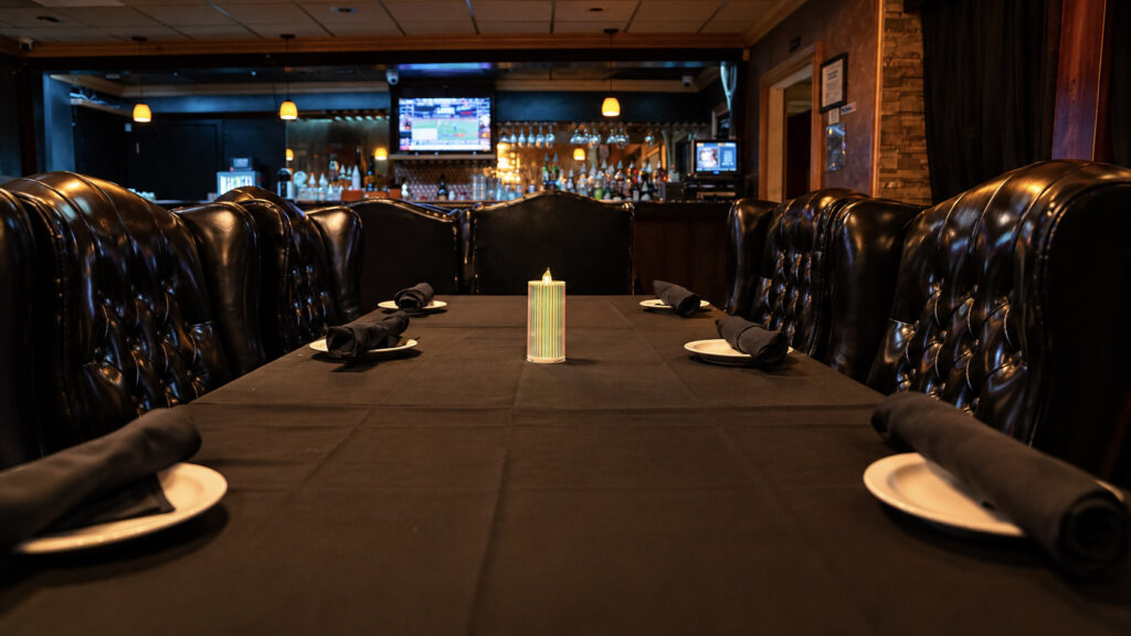 A long dining table set for a group in the steakhouse at Rachel's North in Casselberry, Florida