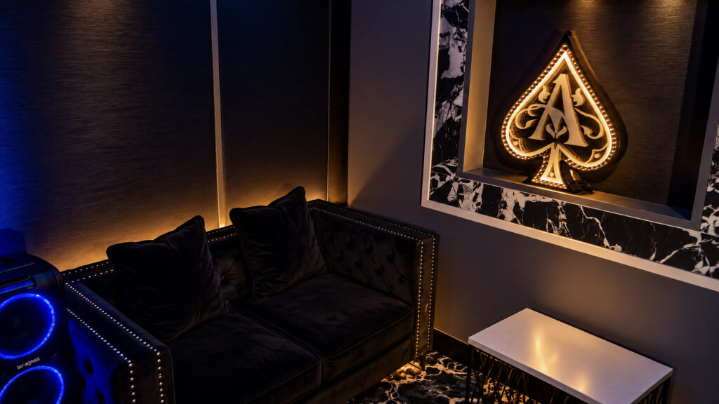 The PJ Room with a velvet sofa and illuminated ace of spades at Rachel's North in Casselberry, Florida
