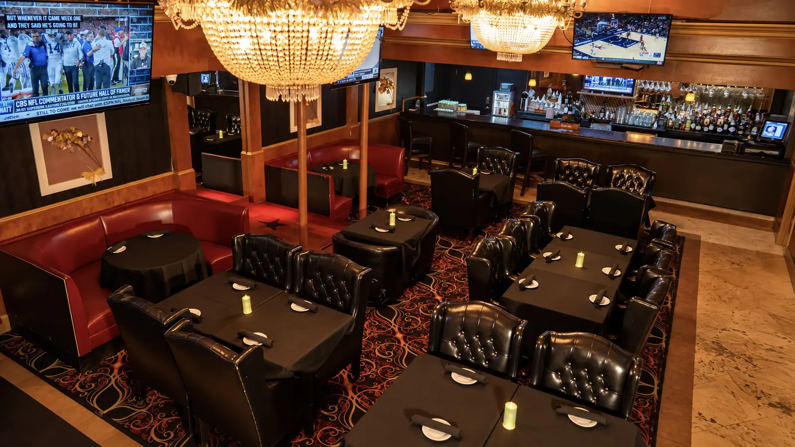 The steakhouse dining room at Rachel's North in Casselberry, with crystal chandeliers, tufted leather chairs, candlelit tables and the bar