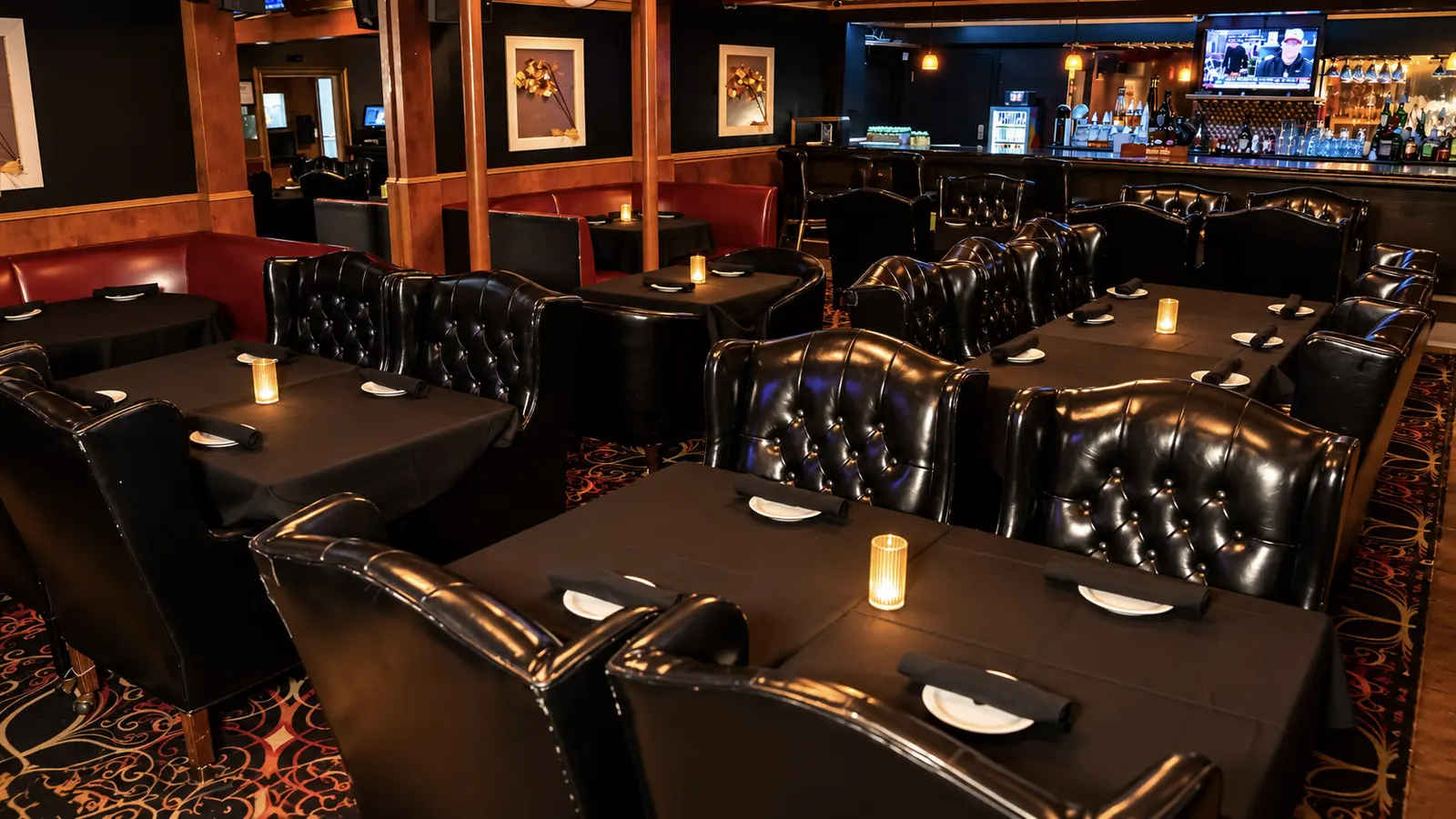 The dining room at Rachel's North steakhouse in Casselberry, Florida: candlelit tables with black linen and tufted leather chairs